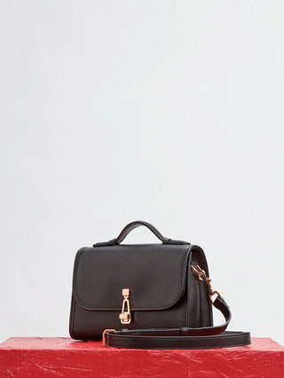 Black Calf Leather Small Leonora Flap Bag - Front View on Red Surface, Top Handle Bag | Gabriela Hearst